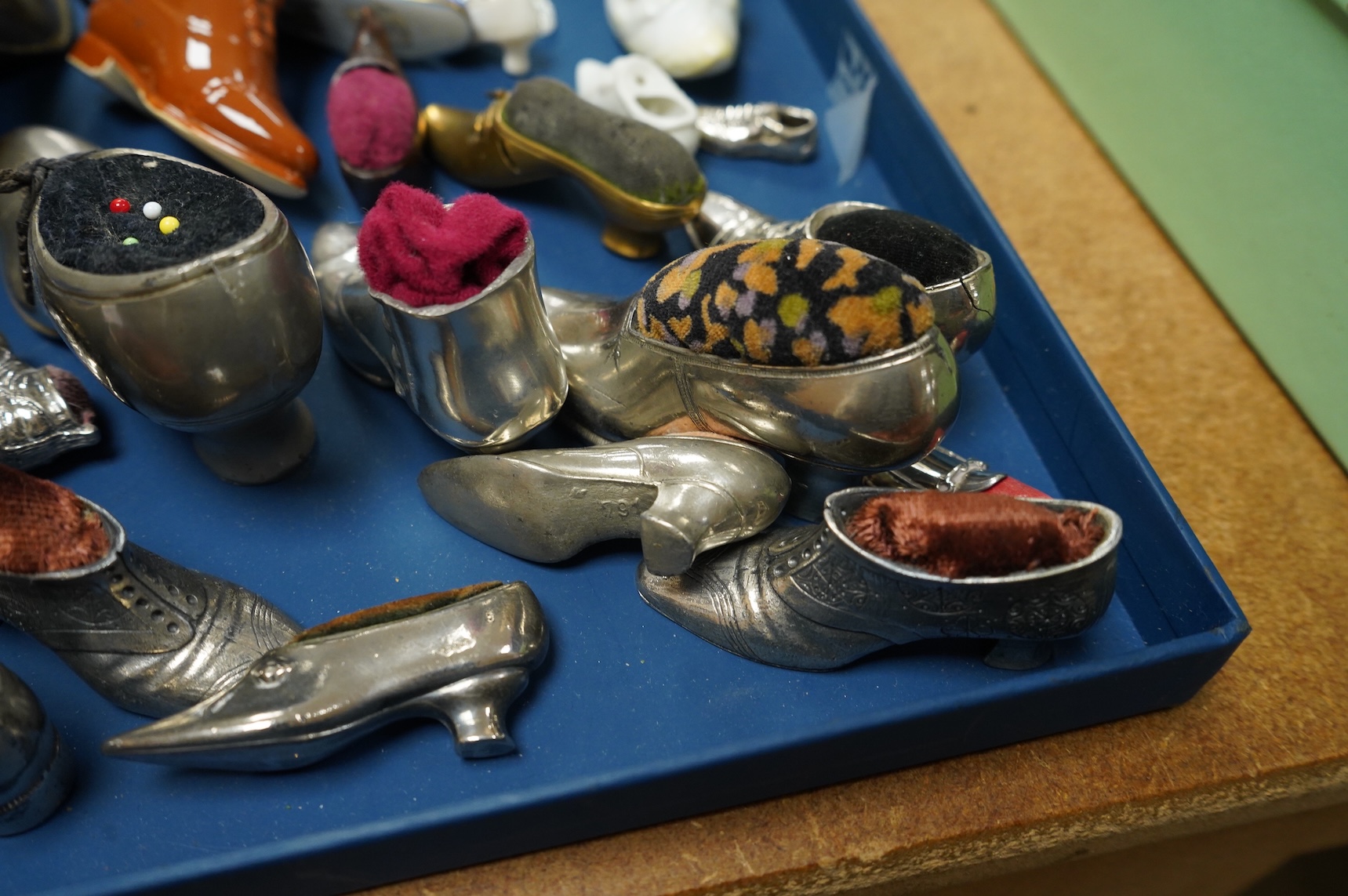 A collection of assorted miniature model shoes including pin cushions, one with modern silver mount